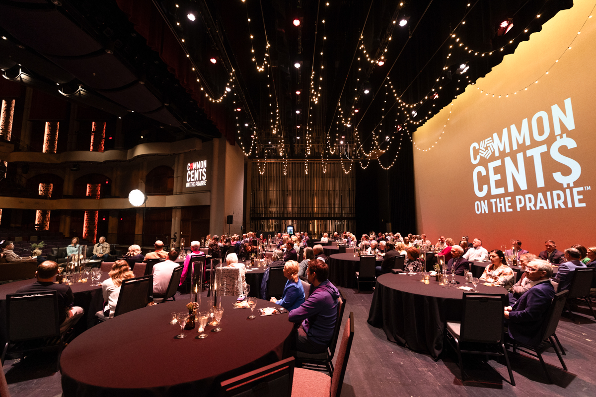 An audience sitting at tables for the Common Cents on the Prairie live event.