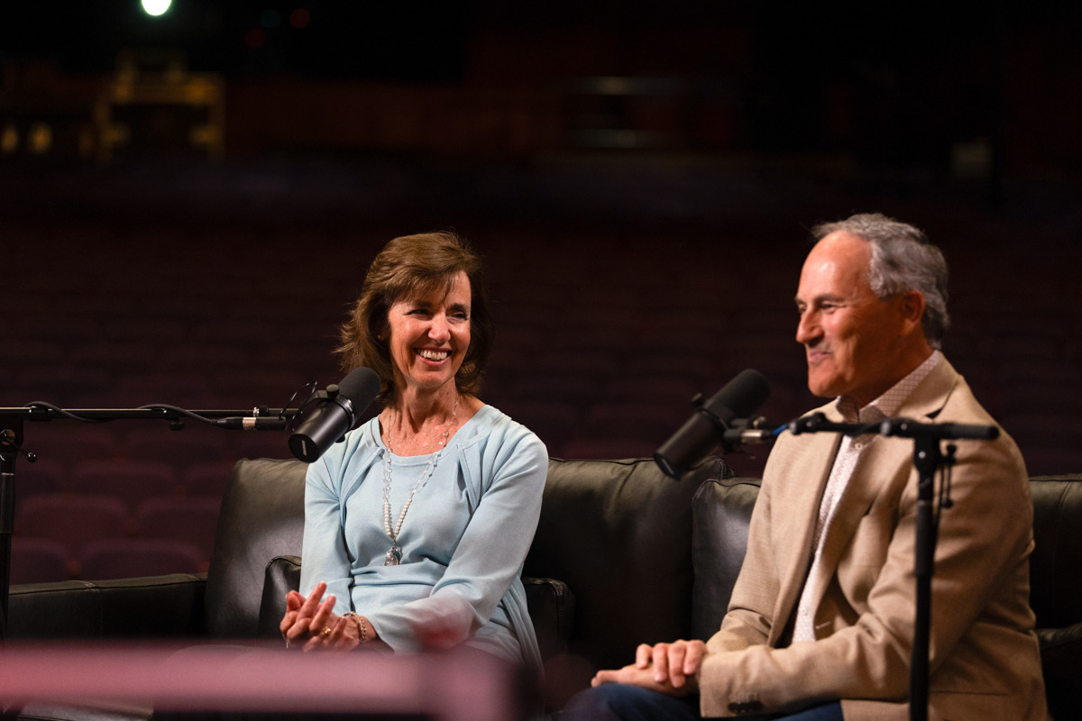 Jean Bender smiling playfully at her husband, Michael, while recording a podcast episode.