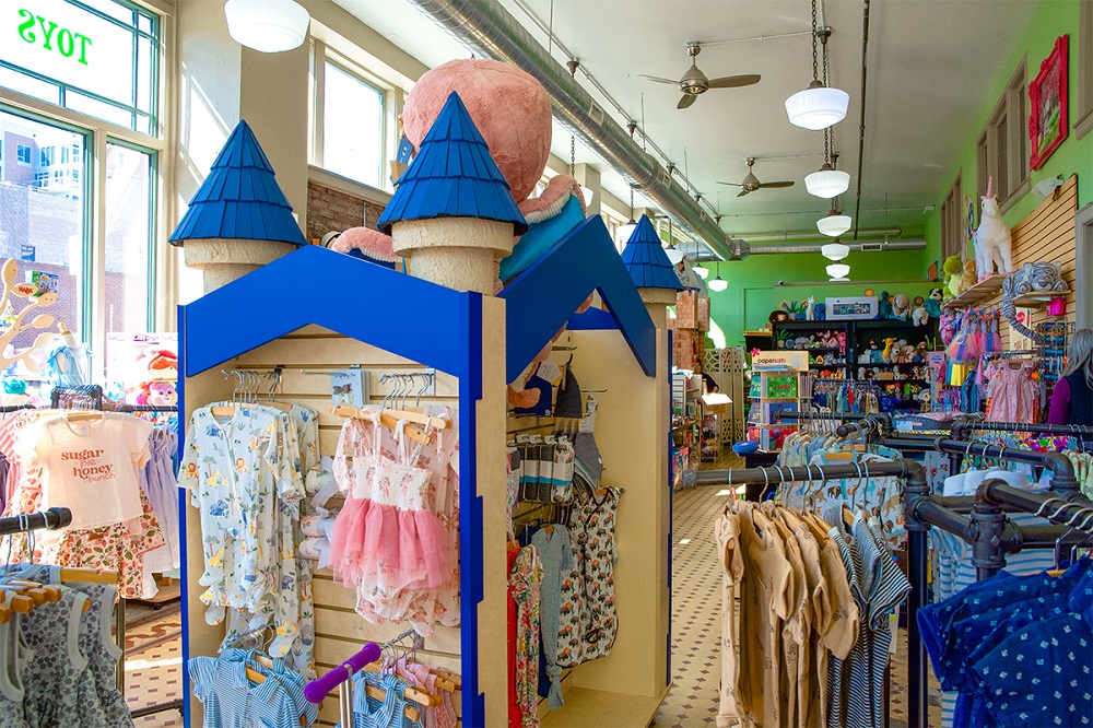 Racks of girls' and boys' clothing in Child's Play Toy.