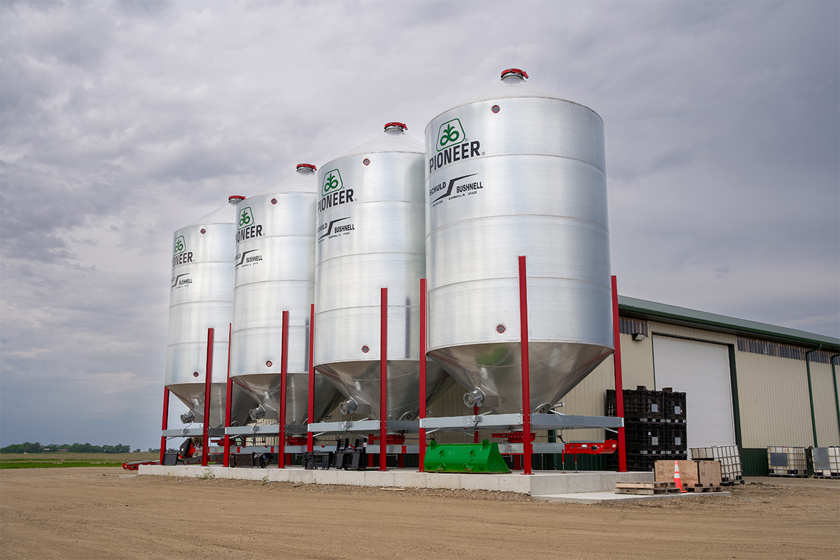 Four bulk Pioneer seed bins on the side of Lakeco Crop Services' warehouse.