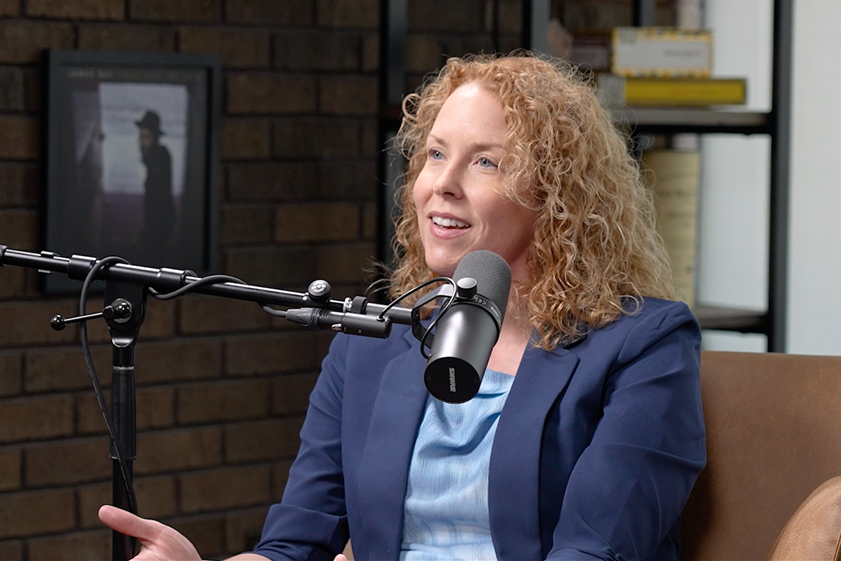 Cindy Peterson sitting by a microphone, recording a podcast episode.