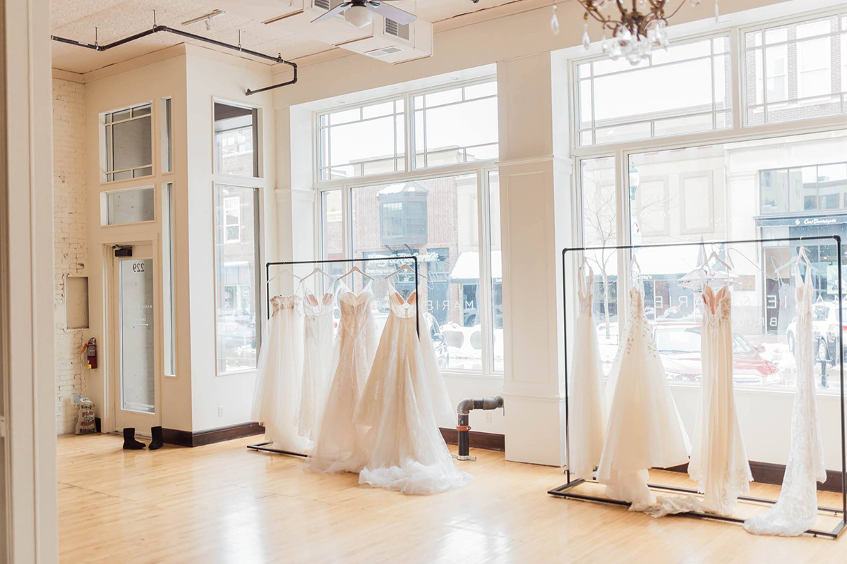 Wedding dresses hanging on racks in Marie and Marie Bridal.