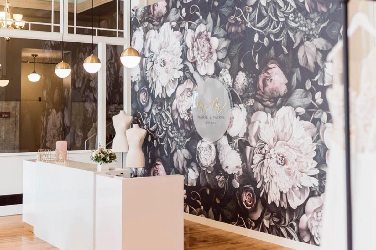 The floral-wallpapered entrance and front desk of Marie and Marie Bridal.