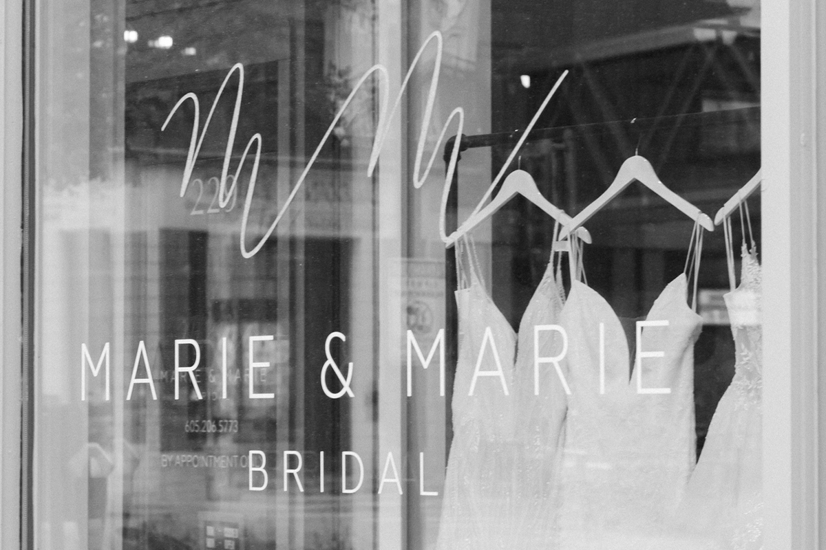 Wedding dresses hanging in the front window of Marie and Marie Bridal.