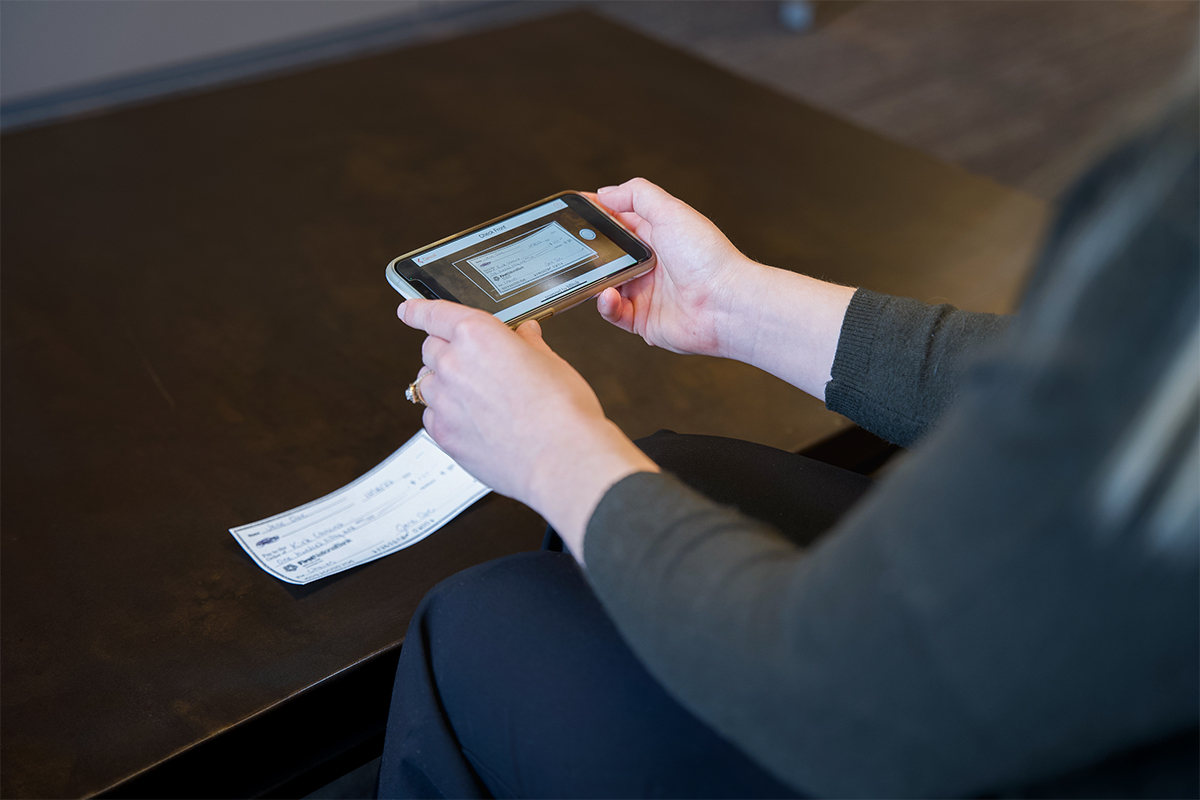 A person using mobile deposit to deposit a check with their phone.