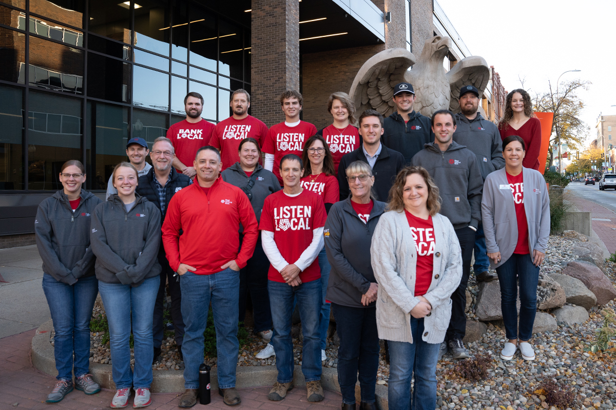 A large group of First National Bank teammates in front of the downtown Sioux Falls eagle statue.