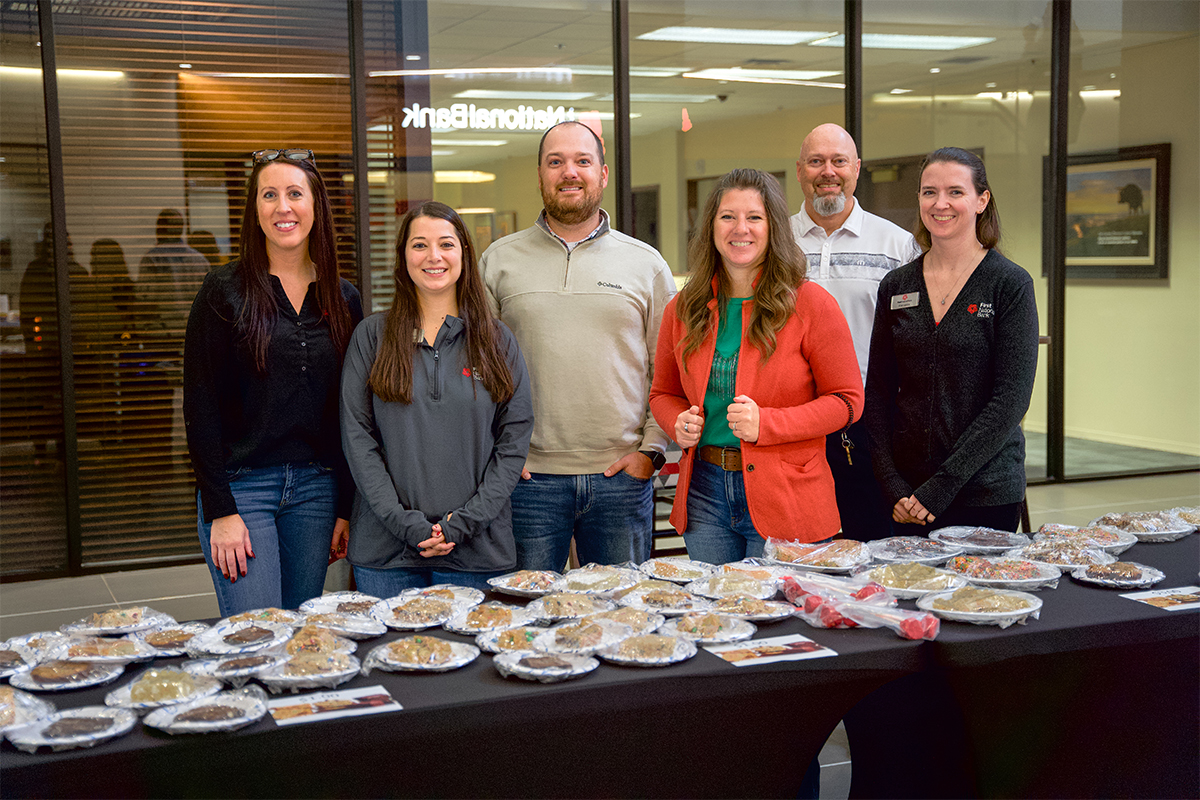 First National Bank's United Way committee standing behind a bake sale table.