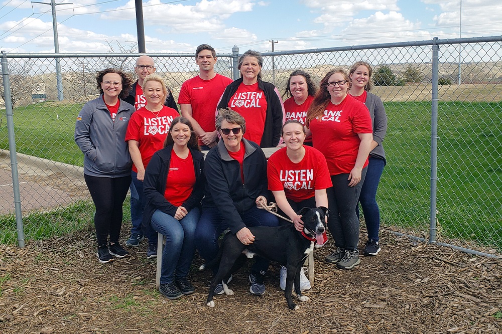 A group of First National Bank teammates posing with a dog at the Sioux Falls Area Humane Society.