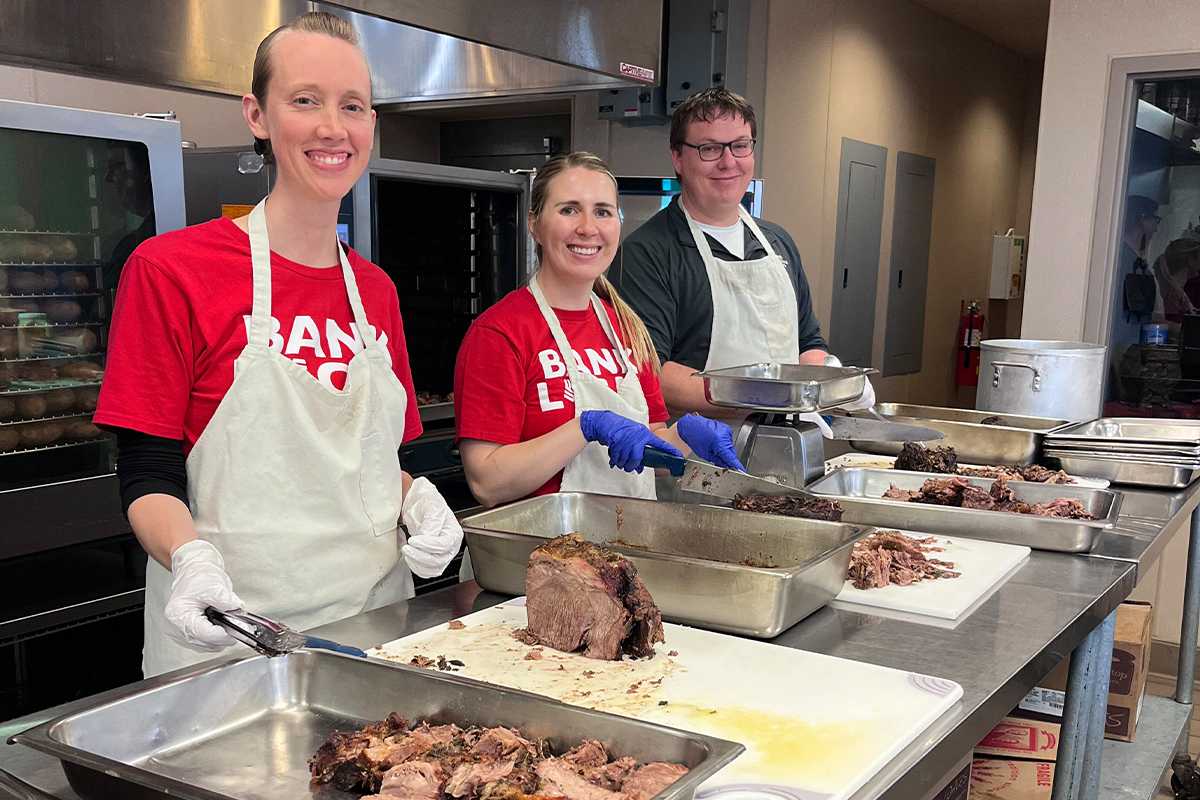 First National Bank teammates cutting meat at The Banquet.