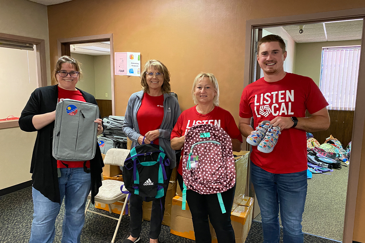 First National Bank teammates holding backpacks at The Foster Network.