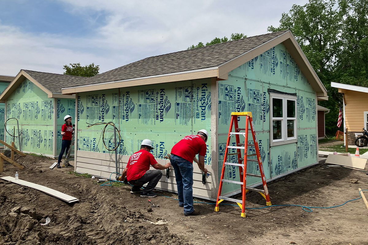 First National Bank teammates siding a tiny house at the Veterans Community Project.